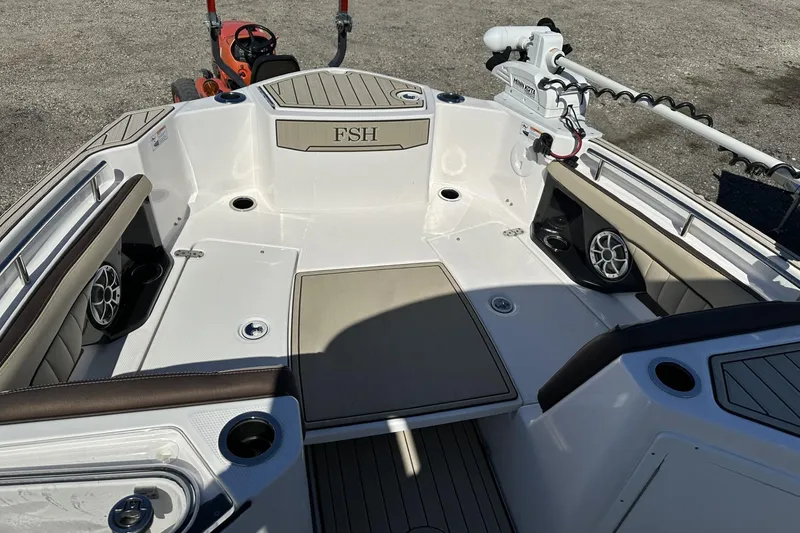 Slide: The Image of 2024 Yamaha Boats 252 FSH Sport interior with seating, speakers, and trolling motor. - 9