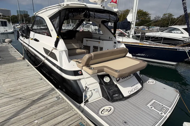 Slide: The Image of 2014 Regal 35 Sport Coupe yacht docked in a marina, surrounded by sailboats. - 3
