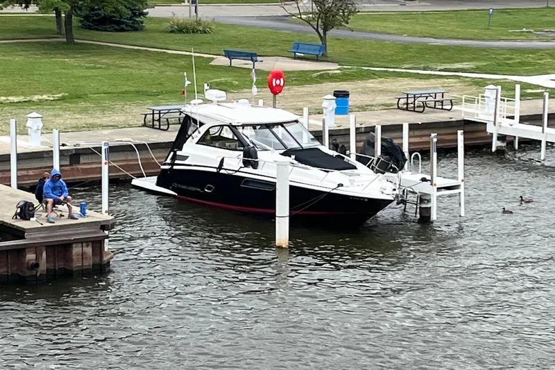 Slide: The Image of 2014 Regal 35 Sport Coupe docked at a marina with surrounding boats. - 9