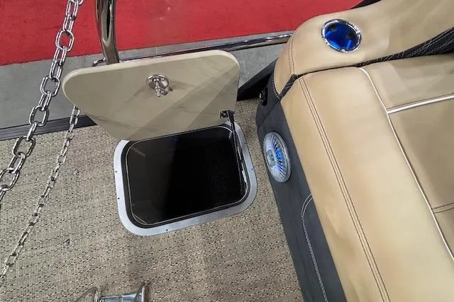 Slide: The Image of 2026 Barletta Lusso 25UC boat interior with open storage compartment and beige seating. - 18