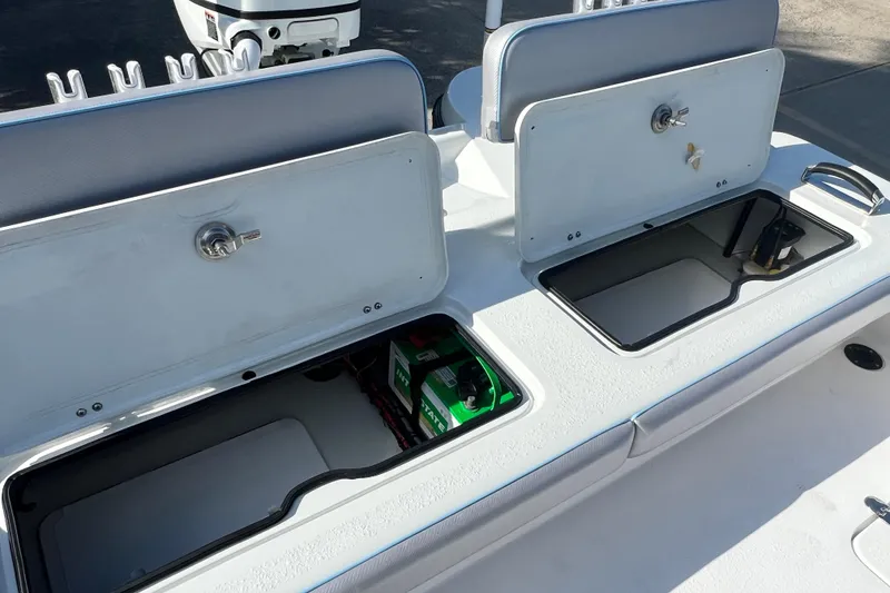 Slide: The Image of 2026 Shallow Stalker The Boss boat storage compartments with open lids and visible battery. - 11