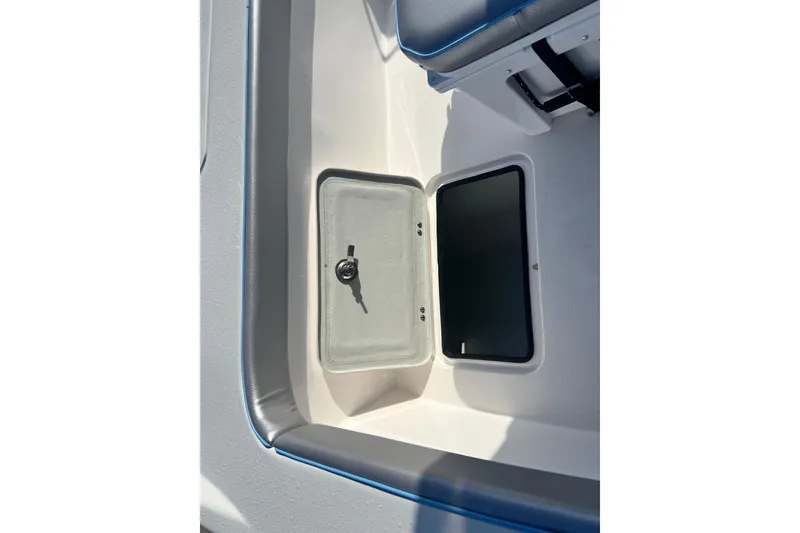 Slide: The Image of 2026 Shallow Stalker The Boss boat storage compartment with open hatch and key. - 18