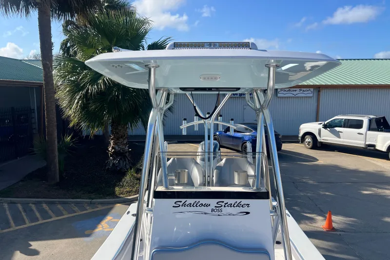 Slide: The Image of 2026 Shallow Stalker "The Boss" boat, parked outdoors, with palm trees and vehicles in the background. - 23
