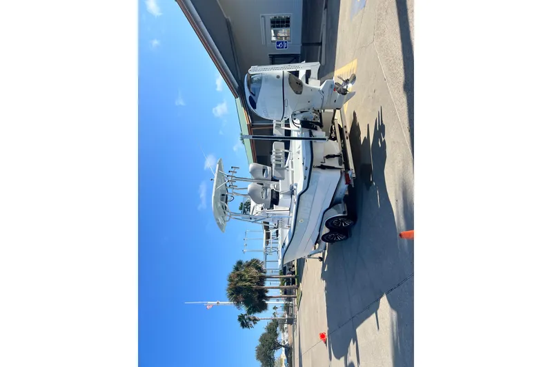 Slide: The Image of 2026 Shallow Stalker The Boss boat on trailer, parked outdoors under clear sky. - 26