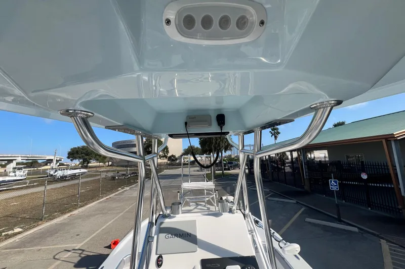 Slide: The Image of 2026 Shallow Stalker The Boss boat with T-top and Garmin electronics, docked outdoors. - 6