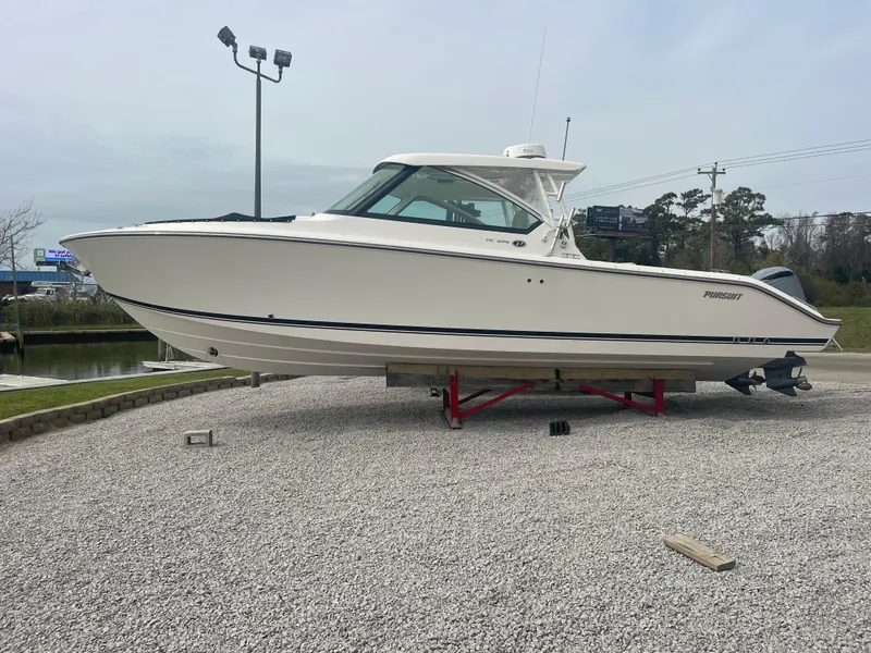 Slide: The Image of 2016 Pursuit DC 325 Dual Console boat displayed on gravel. - 6