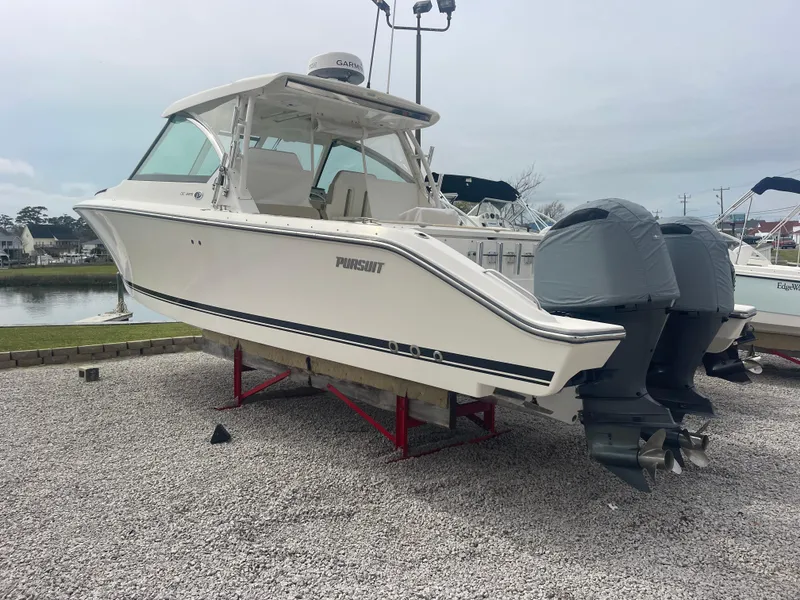 Slide: The Image of 2016 Pursuit DC 325 Dual Console boat displayed on gravel. - 7