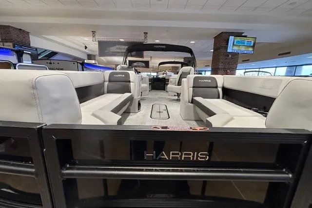 Slide: The Image of 2026 Harris Cruiser 230 pontoon boat interior with spacious seating in showroom. - 10