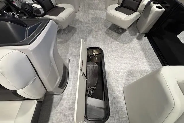 Slide: The Image of 2026 Harris Cruiser 230 interior with open storage compartment and luxurious seating. - 14