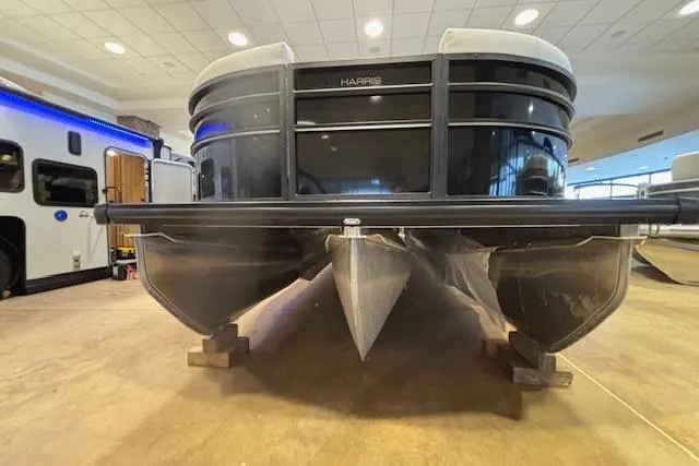 Slide: The Image of 2026 Harris Cruiser 230 pontoon boat displayed indoors on wooden blocks. - 4