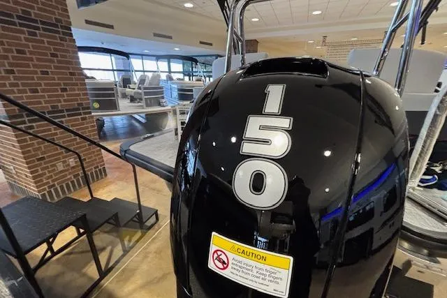 Slide: The Image of 2026 Harris Cruiser 230 with 150 horsepower engine displayed indoors. - 8