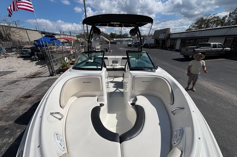 Slide: The Image of 2014 Sea Ray 205 Sport boat with spacious seating, parked outdoors under a clear sky. - 10