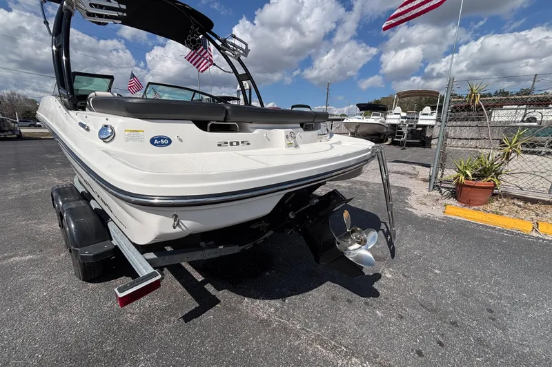 Slide: The Image of 2014 Sea Ray 205 Sport boat on trailer, American flags, sunny day. - 11