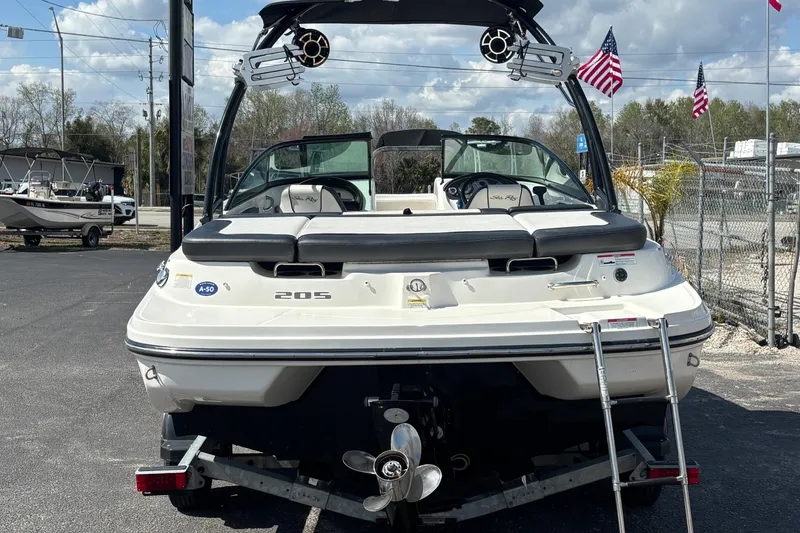 Slide: The Image of 2014 Sea Ray 205 Sport boat on trailer, rear view with American flags in background. - 2