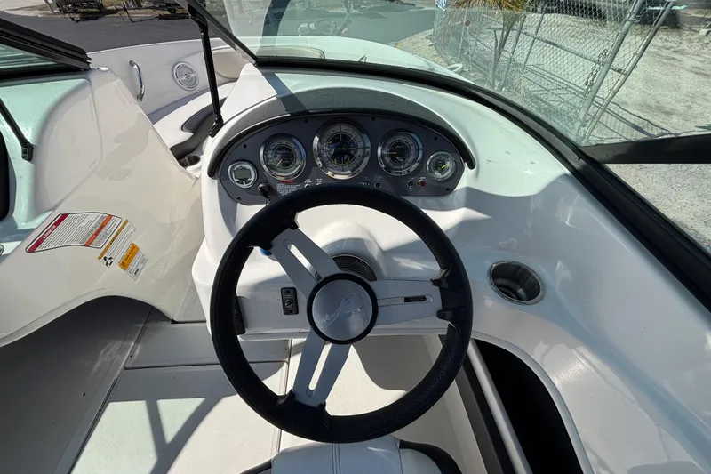 Slide: The Image of 2014 Sea Ray 205 Sport boat dashboard with steering wheel and gauges. - 22