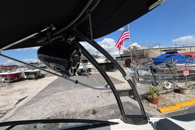 Slide: The Image of 2014 Sea Ray 205 Sport boat with speaker, American flag, and marina background. - 29