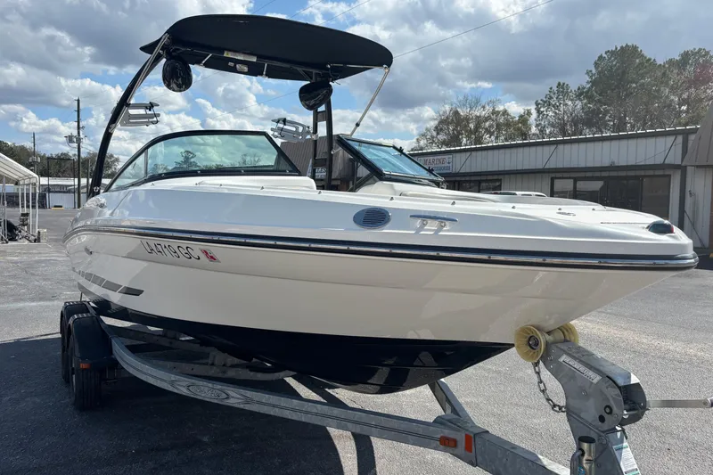 Slide: The Image of 2014 Sea Ray 205 Sport boat on trailer, parked outdoors under cloudy sky. - 5