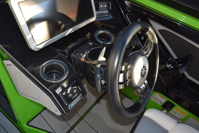 Slide: The Image of Interior of 2022 Yamaha Boats 255XD, featuring steering wheel and control panel. - 21