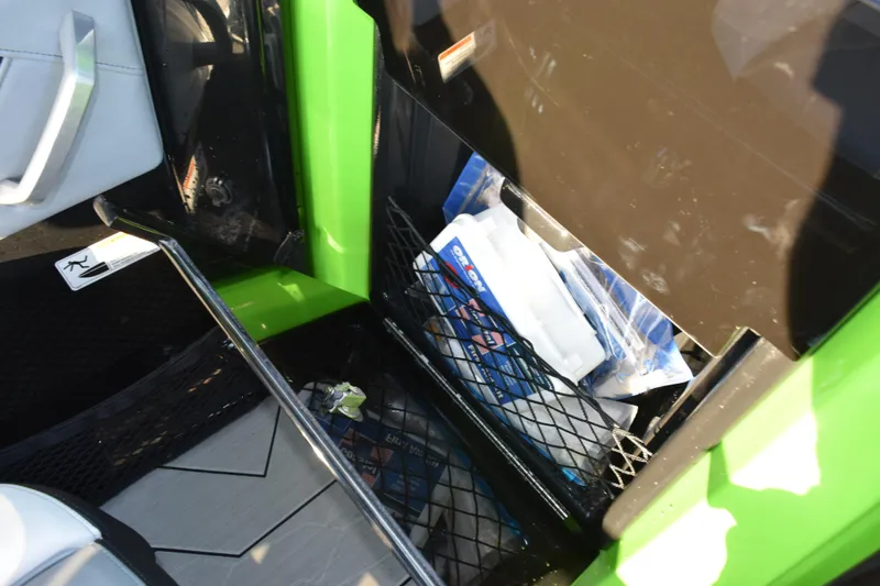 Slide: The Image of Storage compartment in 2022 Yamaha Boats 255XD, featuring netted storage with various items. - 23
