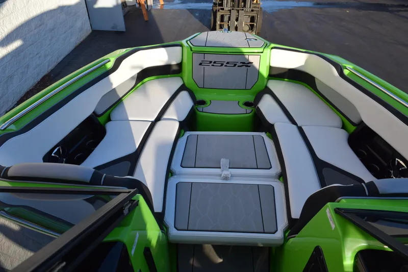 Slide: The Image of 2022 Yamaha Boats 255XD interior with green and white seating, cup holders, and storage. - 26