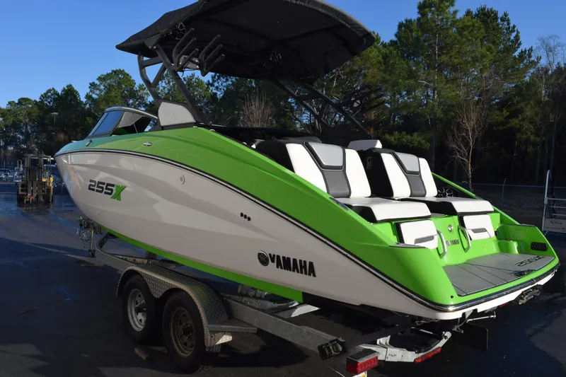 Slide: The Image of 2022 Yamaha Boats 255XD in vibrant green on a trailer, parked outdoors. - 6