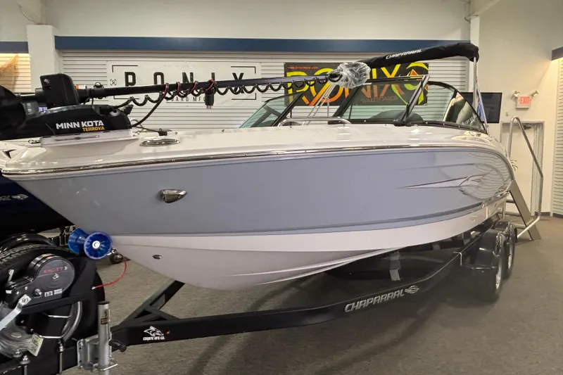 Slide: The Image of 2026 Chaparral 21 SSi Ski & Fish boat displayed indoors on a trailer. - 2