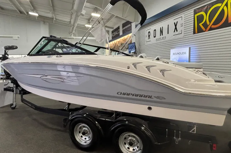 Slide: The Image of 2026 Chaparral 21 SSi Ski & Fish boat displayed indoors on a trailer. - 3
