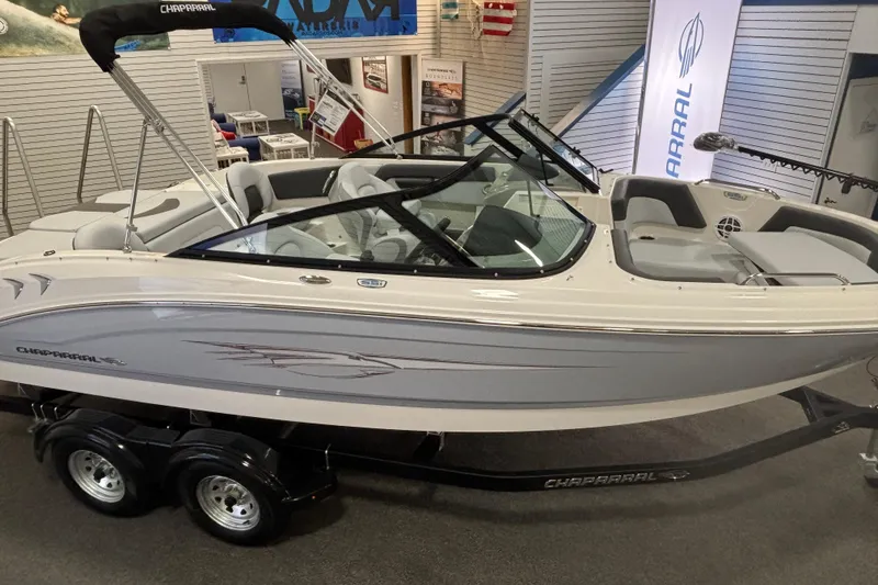 Slide: The Image of 2026 Chaparral 21 SSi Ski & Fish boat displayed indoors on a trailer. - 6