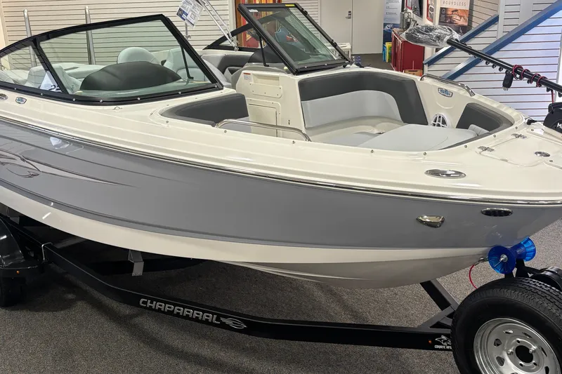 Slide: The Image of 2026 Chaparral 21 SSi Ski & Fish boat displayed indoors on a trailer. - 8