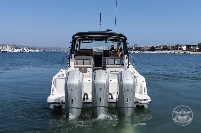 Slide: The Image of 2025 Boston Whaler 405 Conquest boat with triple outboard engines on water. - 14