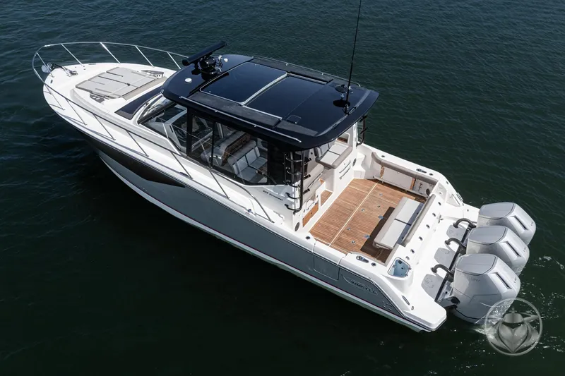 Slide: The Image of 2025 Boston Whaler 405 Conquest boat on water, featuring sleek design and triple outboard engines. - 18