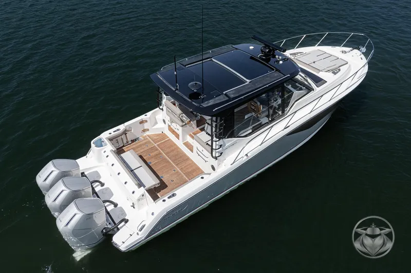 Slide: The Image of 2025 Boston Whaler 405 Conquest boat on water, featuring sleek design and triple outboard engines. - 19