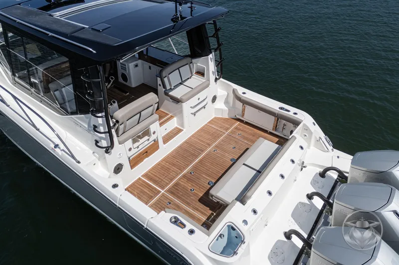 Slide: The Image of 2025 Boston Whaler 405 Conquest boat with spacious deck and seating, docked on water. - 26