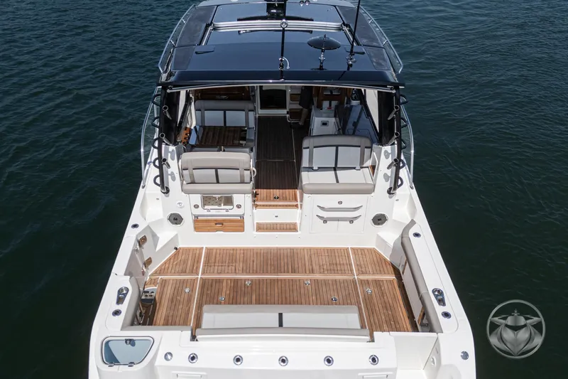 Slide: The Image of 2025 Boston Whaler 405 Conquest boat with spacious deck and seating, on calm water. - 27