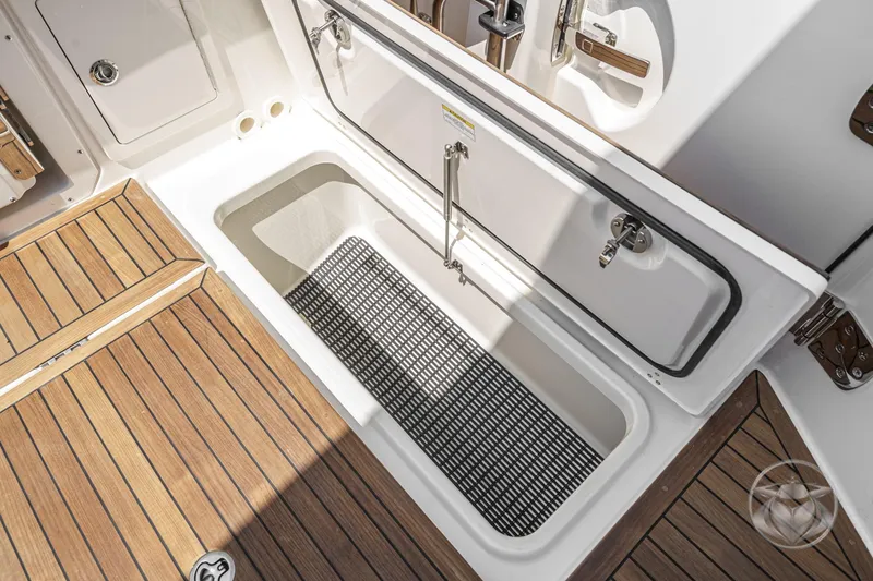 Slide: The Image of 2025 Boston Whaler 405 Conquest deck storage with open hatch and wooden flooring. - 37