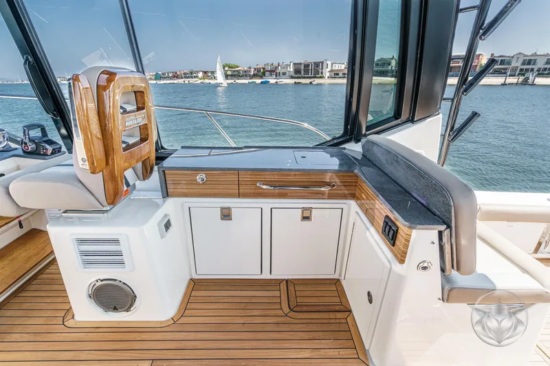 Slide: The Image of 2025 Boston Whaler 405 Conquest interior with sleek wood finish and waterfront view. - 47