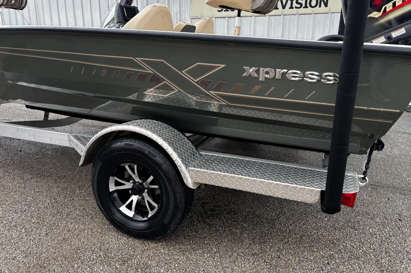 Slide: The Image of Yamaha VMAX outboard motor on 2021 Xpress X18PFC boat, parked near a white building. - 22