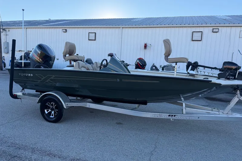 Slide: The Image of 2021 Xpress X18PFC boat on trailer, featuring Yamaha 115 engine, parked outdoors. - 34