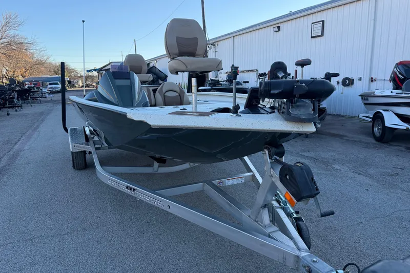 Slide: The Image of 2021 Xpress X18PFC fishing boat on trailer, parked outdoors near a white building. - 37