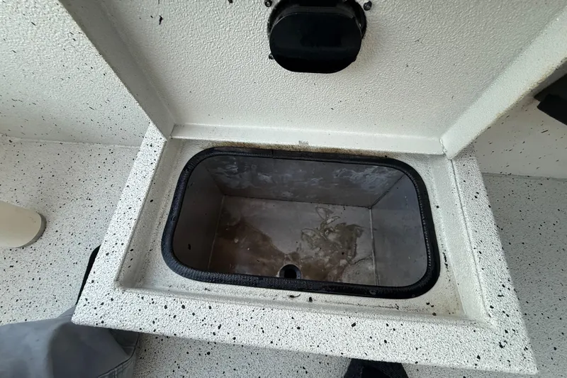 Slide: The Image of Open storage compartment in 2021 Xpress X18PFC boat, featuring speckled interior design. - 61