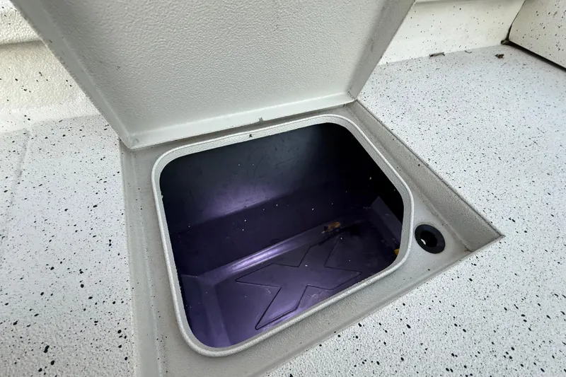 Slide: The Image of Open storage compartment on 2021 Xpress X18PFC boat deck. - 74