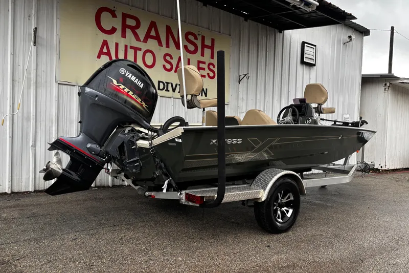 Slide: The Image of 2021 Xpress X18PFC boat on trailer, parked outdoors under clear blue sky. - 9