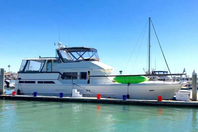 The Image of 1984 Spindrift 52 Motoryacht docked in a sunny marina, featuring a sleek design. - 1