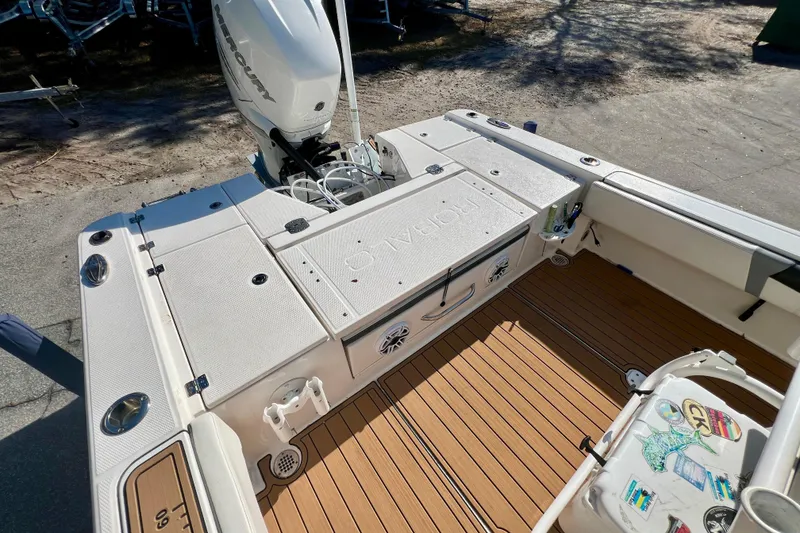 Slide: The Image of 2023 Robalo 266 Cayman boat deck with Mercury engine, featuring spacious seating and storage. - 14