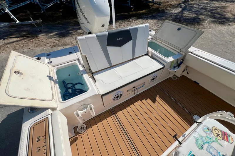 Slide: The Image of 2023 Robalo 266 Cayman boat interior with seating, storage compartments, and teak flooring. - 15