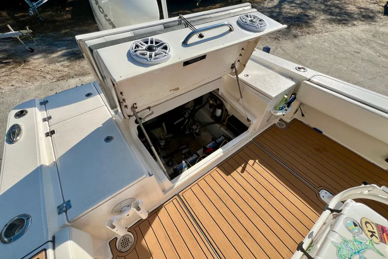 Slide: The Image of 2023 Robalo 266 Cayman boat interior with open storage compartment and teak flooring. - 16