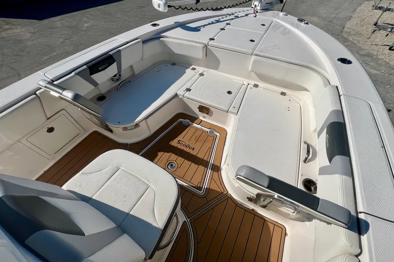 Slide: The Image of 2023 Robalo 266 Cayman boat interior with cushioned seating and teak-style flooring. - 7