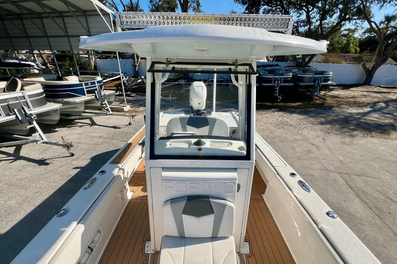 Slide: The Image of 2023 Robalo 266 Cayman boat interior with seating and console, parked outdoors. - 9