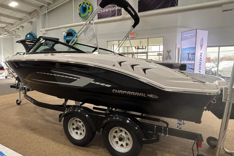 Slide: The Image of 2026 Chaparral 21 SSi boat on display in showroom, black and white design. - 5