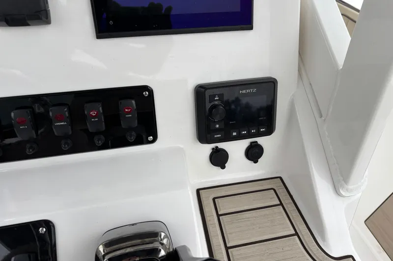 Slide: The Image of Control panel of 2023 Yamaha Boats 222 FSH Sport with switches and audio system. - 10